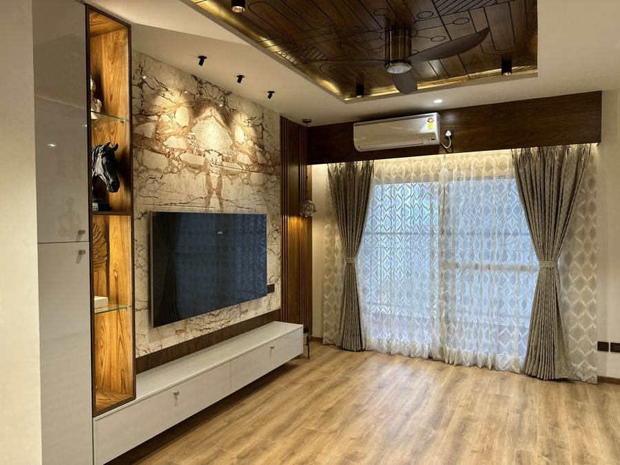 Living room with carved wood false ceiling, marble TV wall and wood flooring